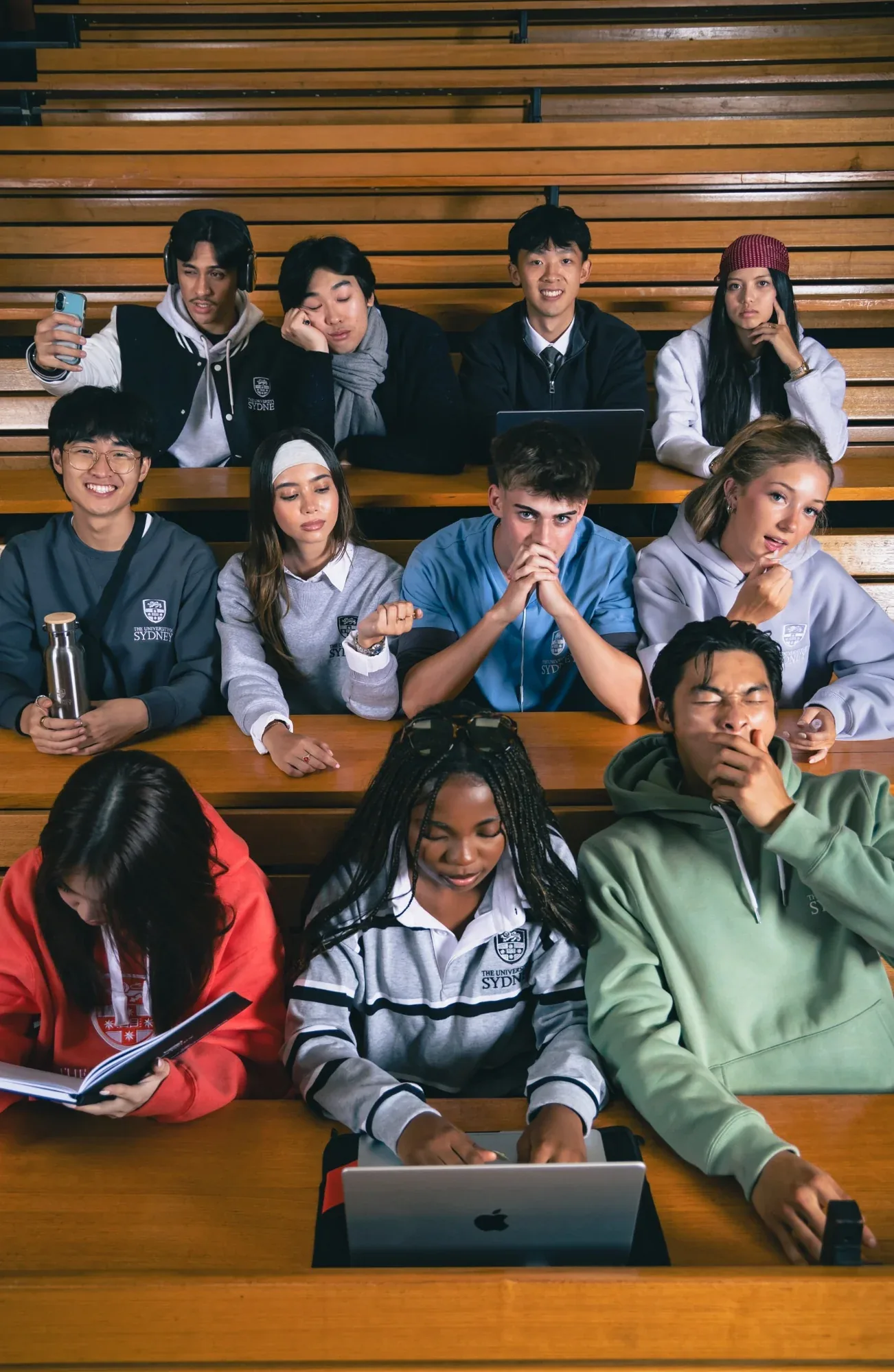 Students in USU merchandise seated in rows of a timber lecture theatre, laptops open